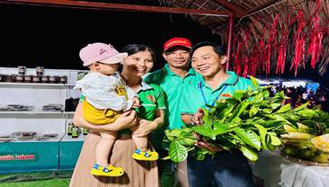 A group of people holding a baby and a bunch of leaves  Description automatically generated