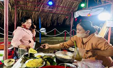 A person serving food at a table  Description automatically generated